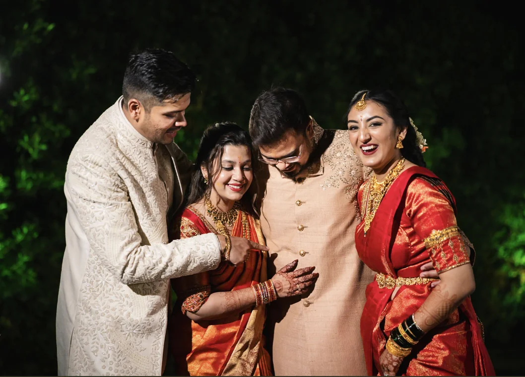 Friends laughing and pointing at the groom during a playful wedding celebration.